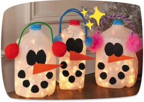 Three illuminated milk jug snowmen decorated with felt faces, carrot noses, and colorful pom-pom earmuffs, displayed as a festive holiday craft.
