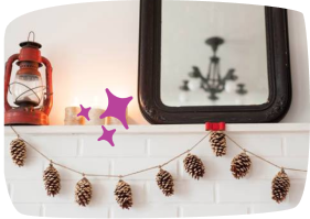 A festive mantelpiece decorated with a pine cone garland, purple star cutouts, and a red vintage lantern next to a mirror.