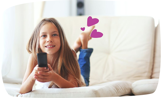 Fetiță pe canapea se uită la televizor